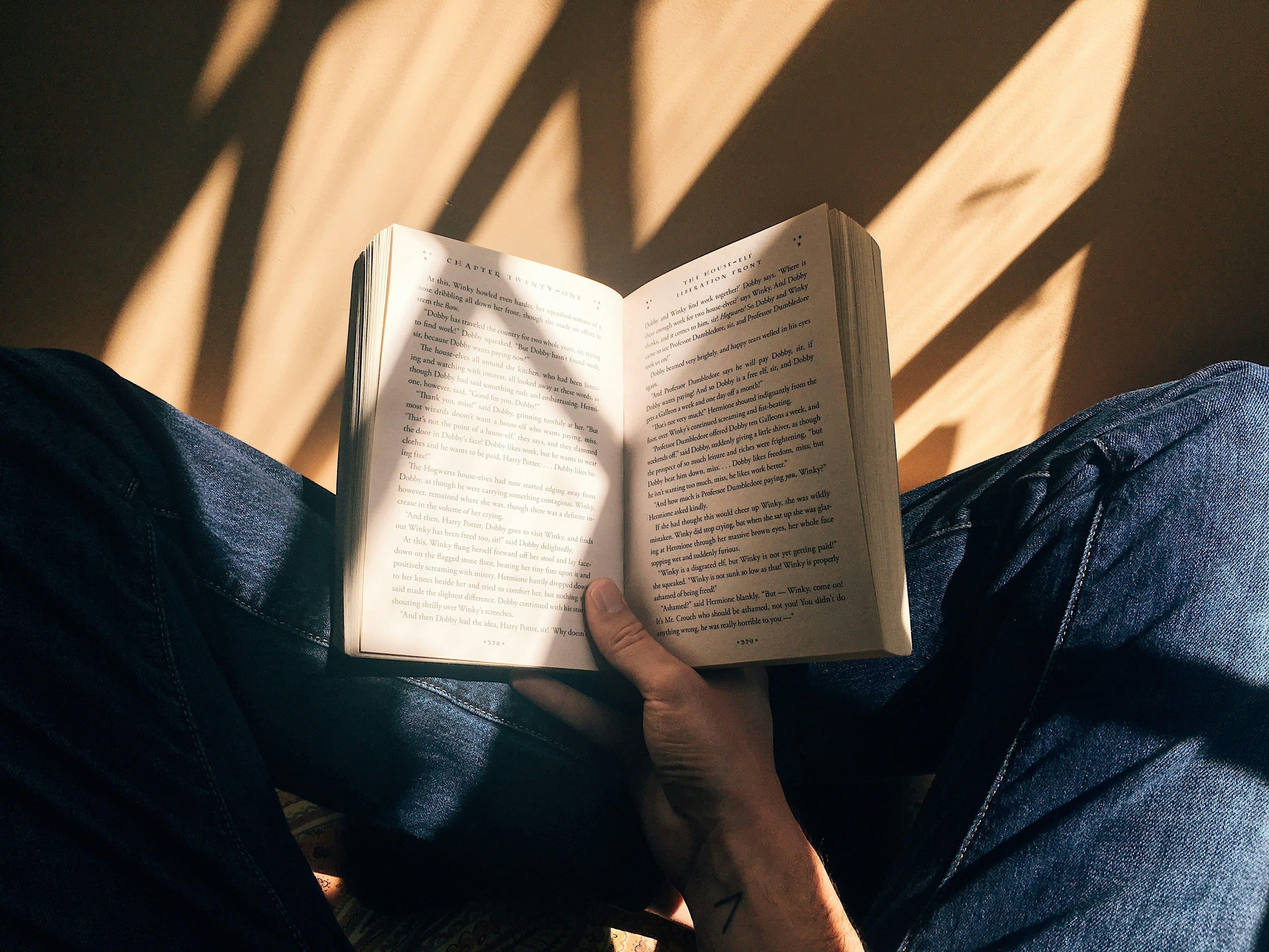 Eine Person hält ein aufgeschlagenes Buch in den Händen