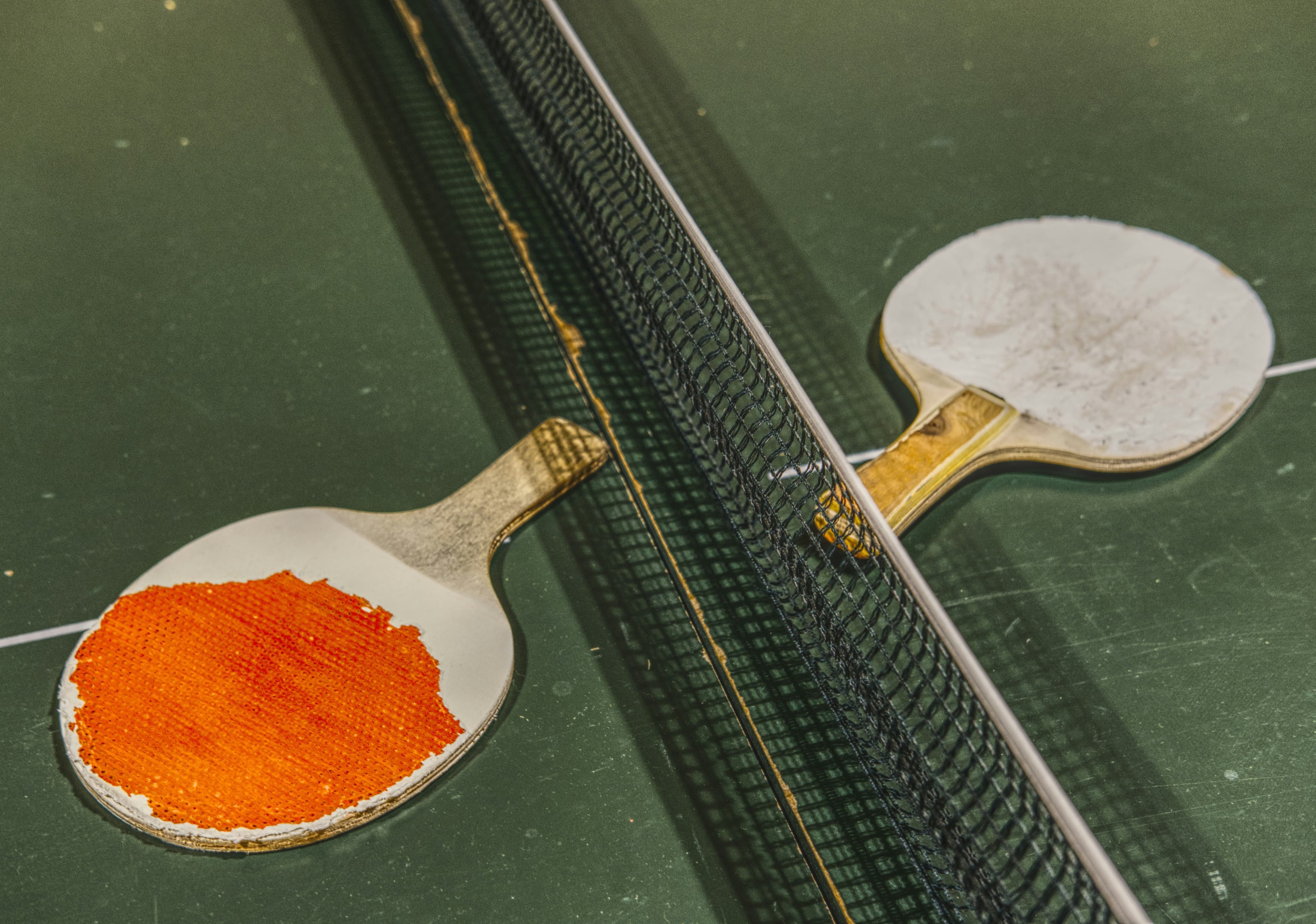 Zwei Tischtennisschläger auf grüner Platte