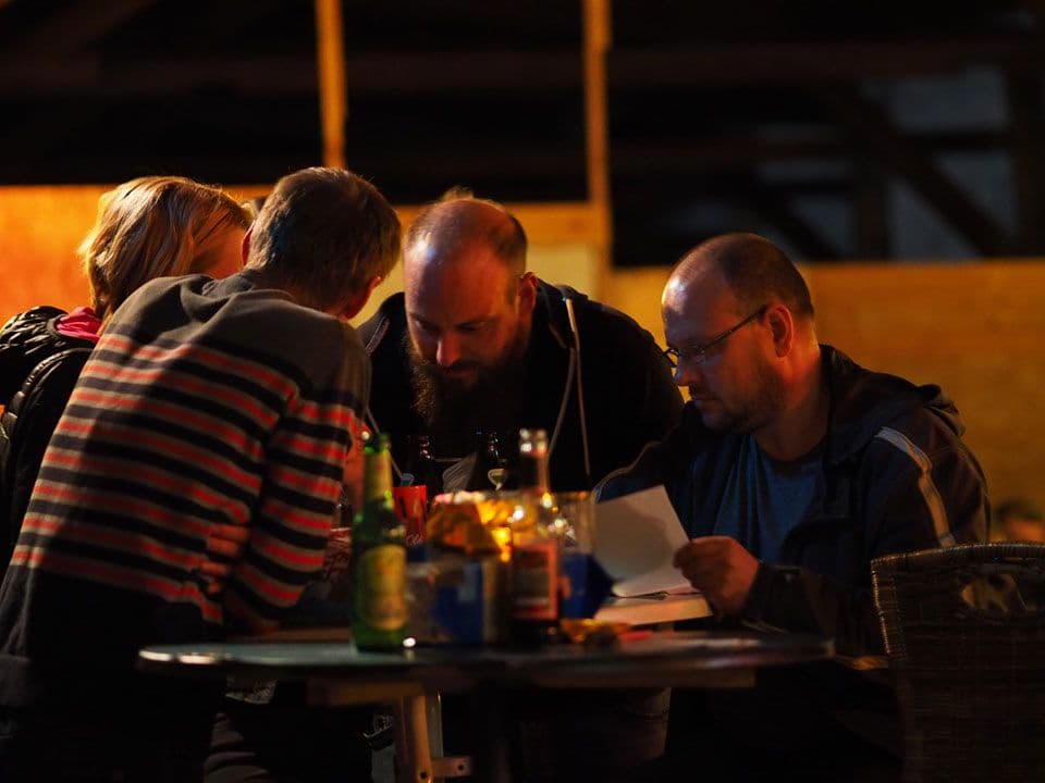 Menschen versuchen in einer Bar ein Quiz auszufüllen