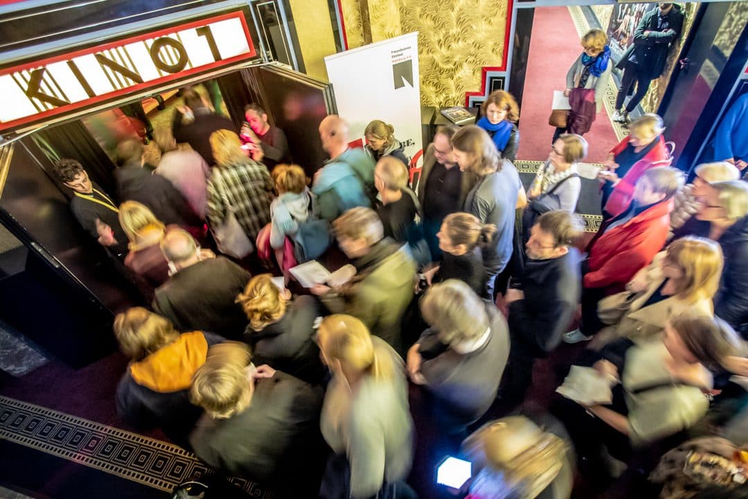Menschen stehen Schlange vor einem Kinosaal