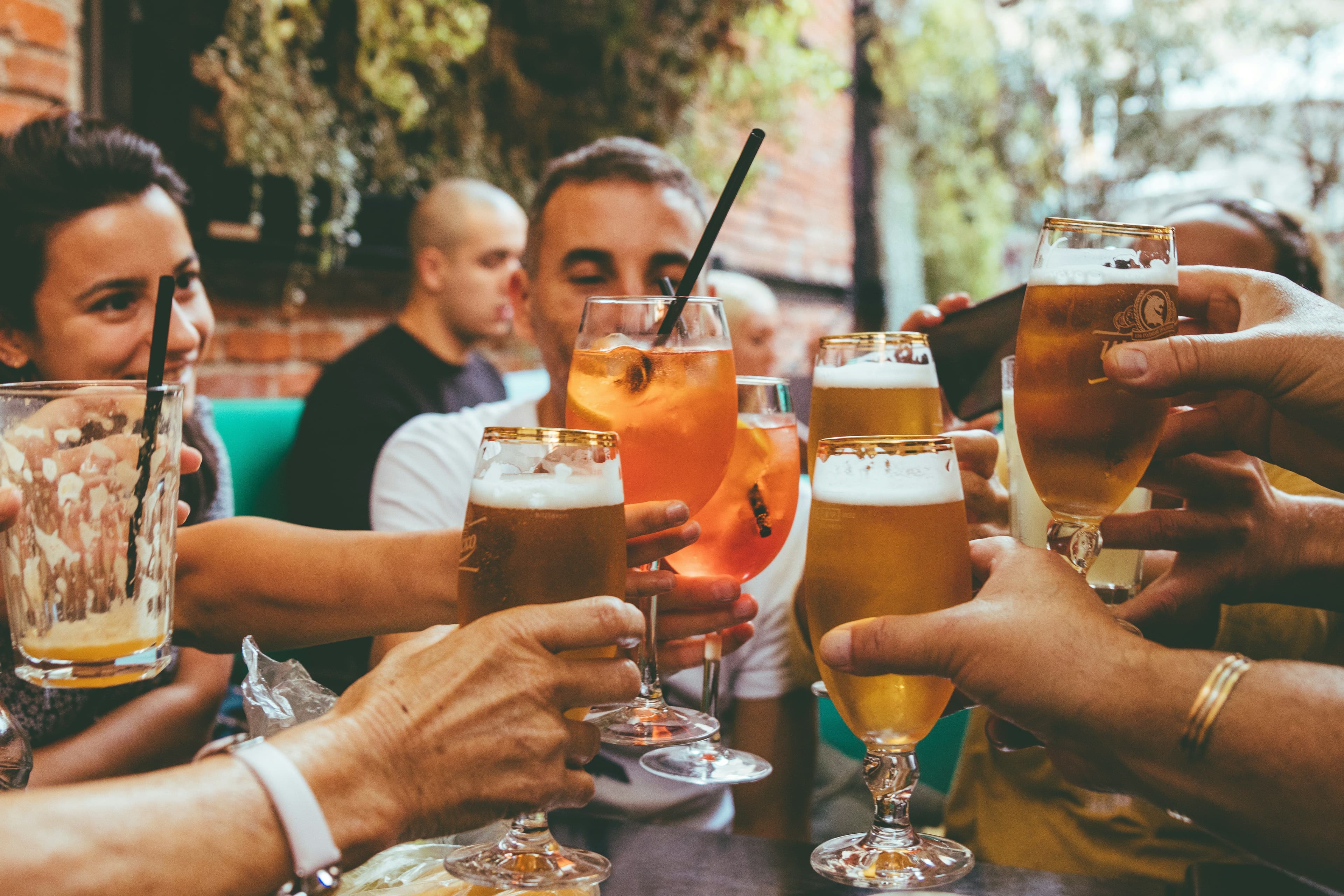 Eine Gruppe Menschen stößt mit verschiedenen Drinks an