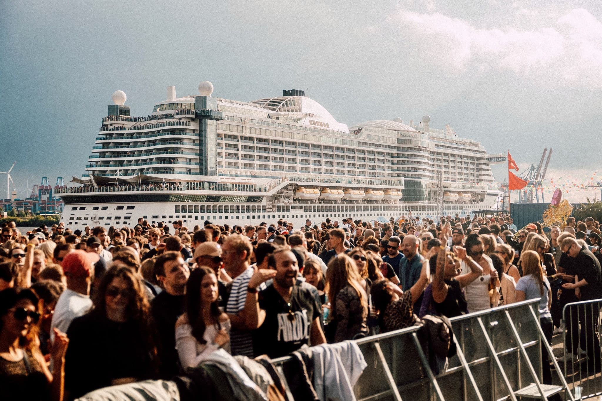 Menschenmasse auf einem Festival am Hafen in Hamburg mit Kreuzfahrtschiff im Hintergrund