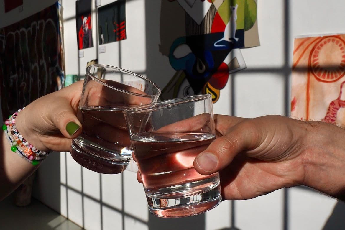 Zwei Menschen stoßen mit Wassergläsern an