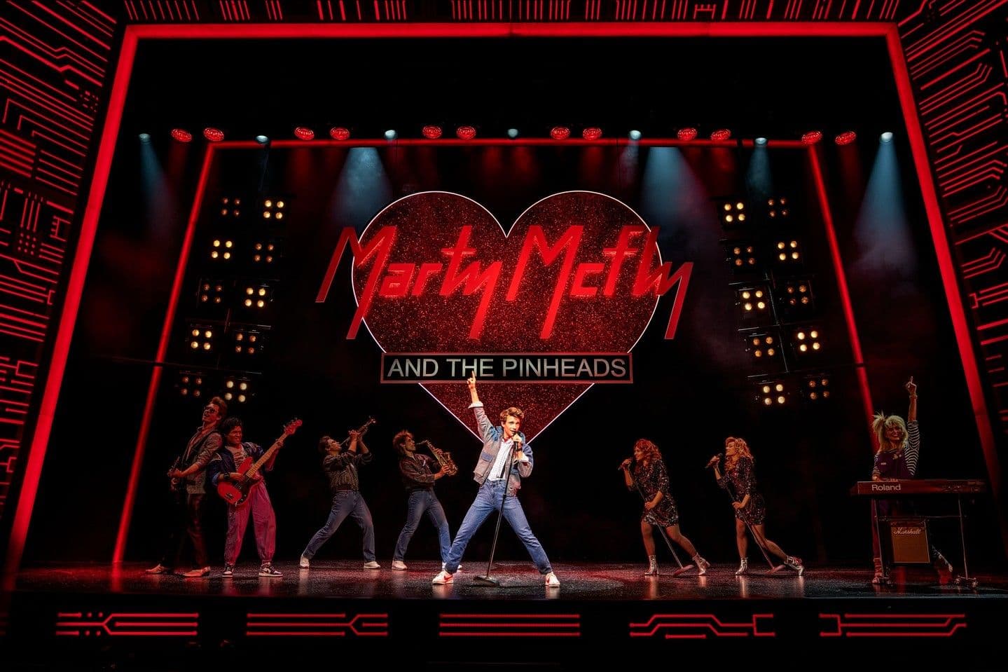 Ein Schauspieler singt auf einer Bühne vor einem "Marty Mcfly"-Schriftzug