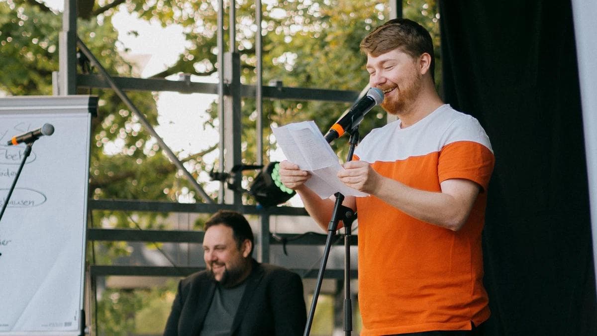 Eine Person mit Mikrofon auf der Bühne