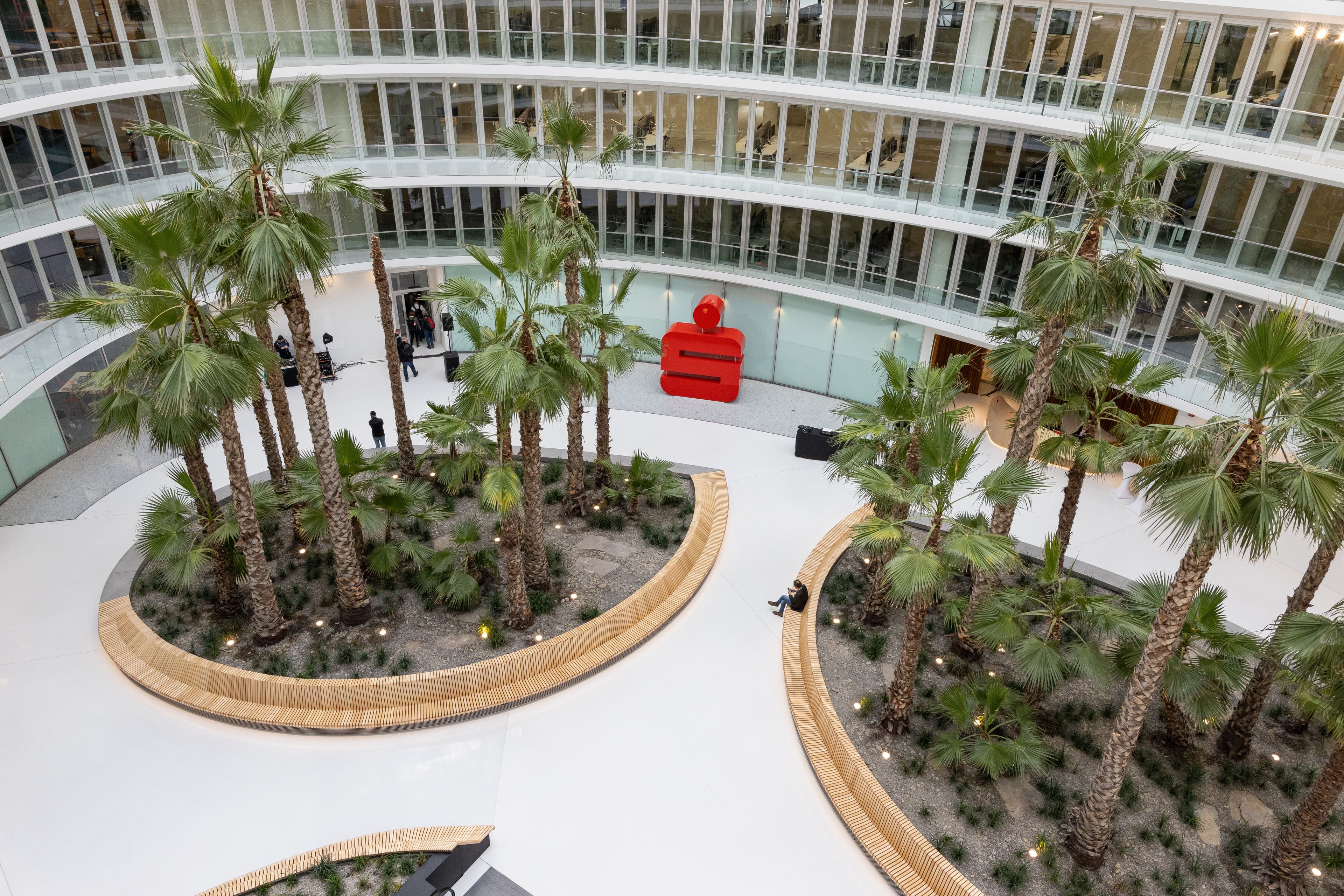 Blick aufs Atrium des Deutschlandhauses mit Palmen rotem Sparkassen-Logo