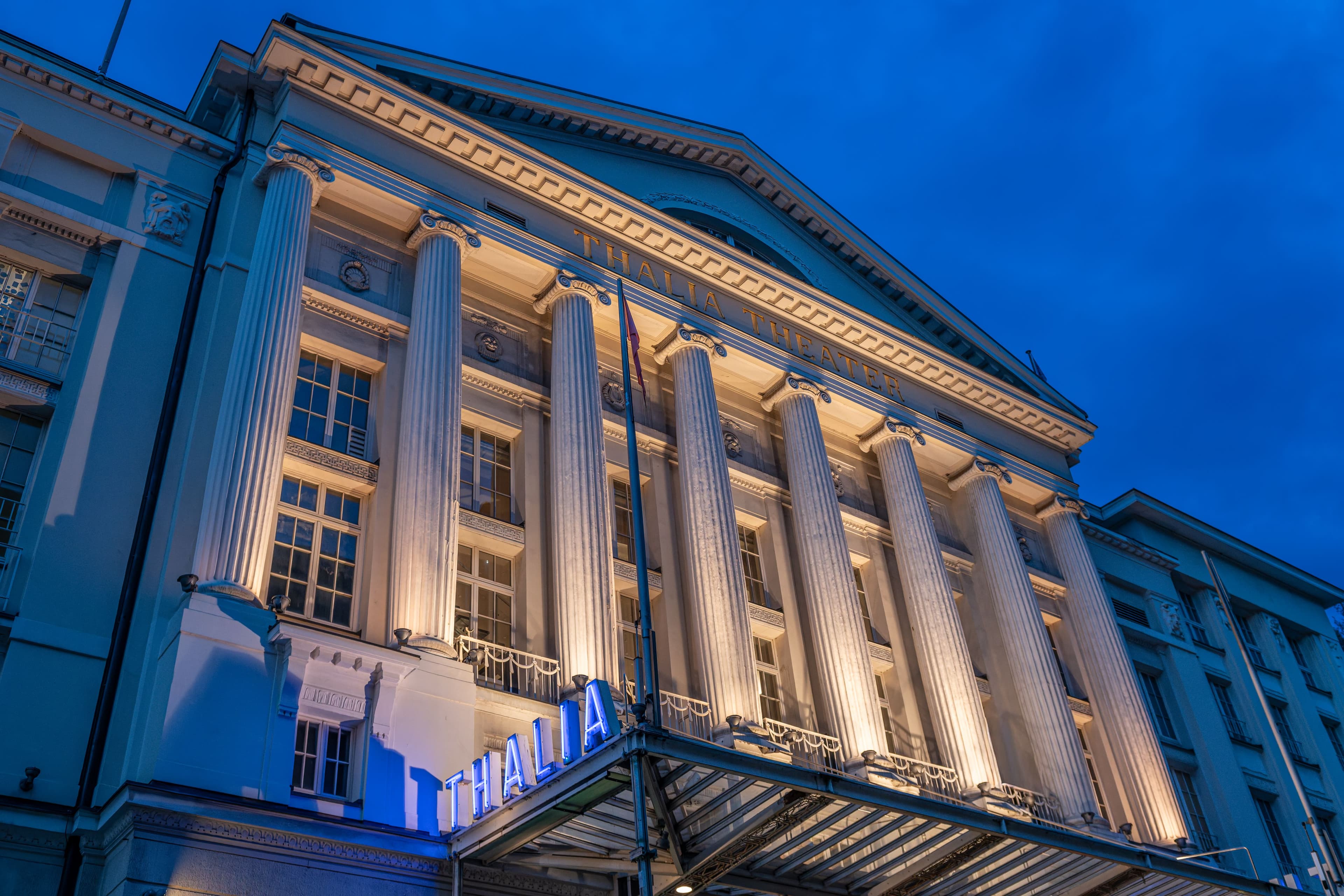 Außenansicht des im Dunkeln beleuchteten Thalia Theaters